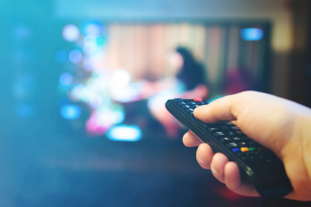 blu ray player person visar fjärrkontroll på tv