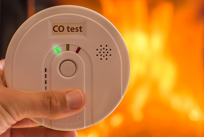 Co-detektor med eld i bakgrunden
