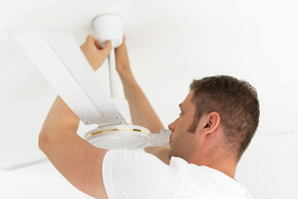 En man installerar en takfläkt