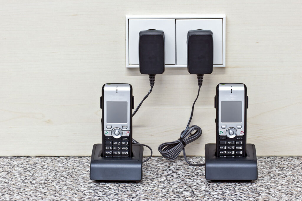 Två trådlösa telefoner i hennes bas