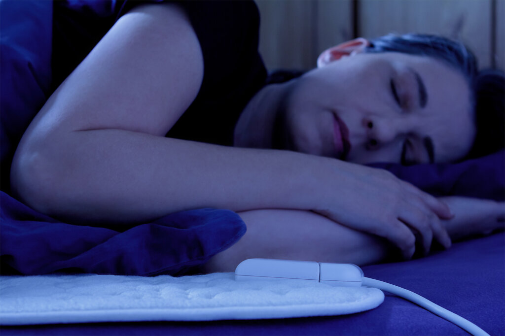 Kvinna sover på elektrisk filt