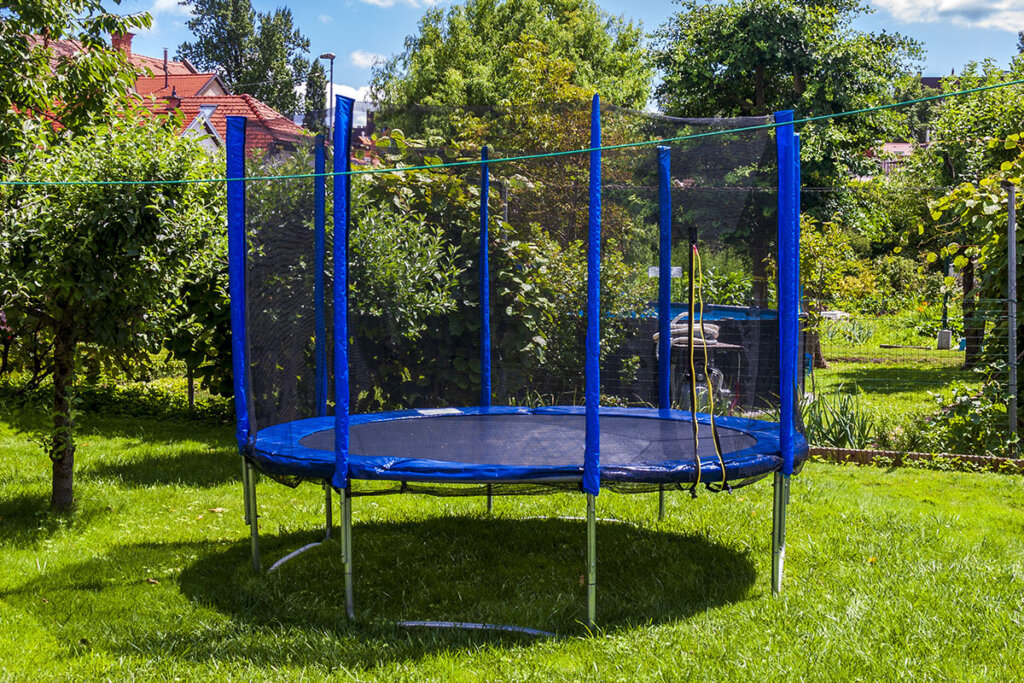 Stor blå studsmatta i trädgården