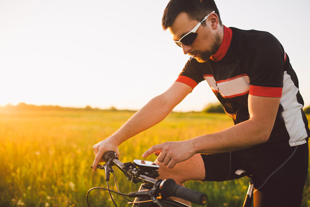 ung cyklist på fältet använder navi