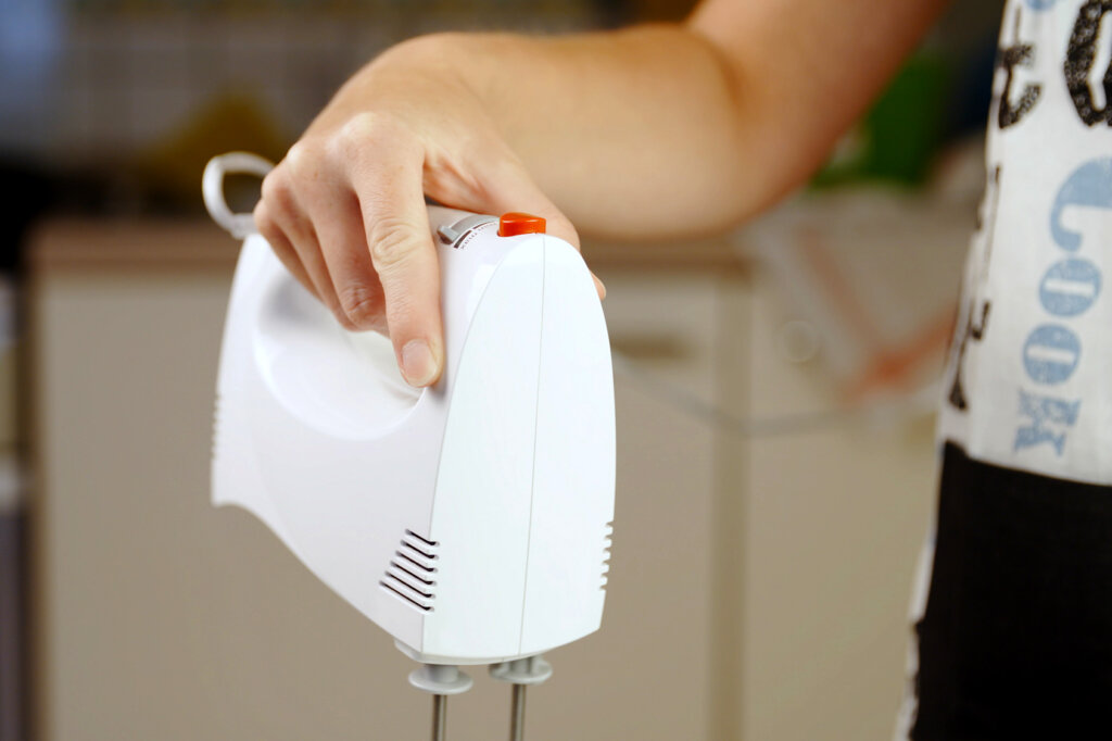 Kvinna som håller en handmixer