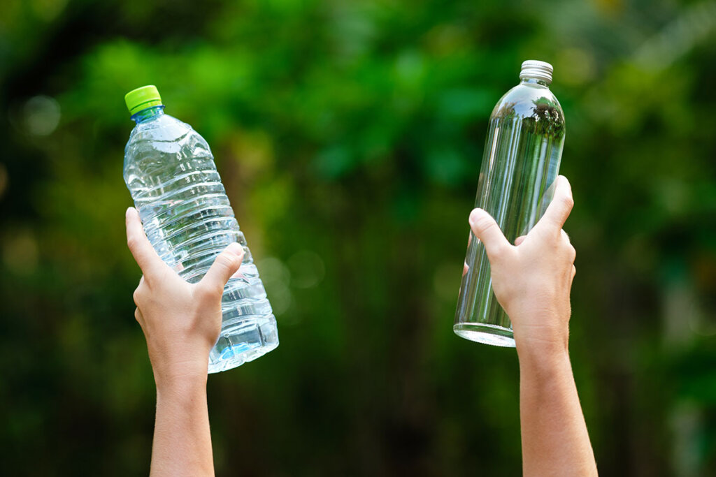 kolsyremaskin hander haller plast och glas flaska upp
