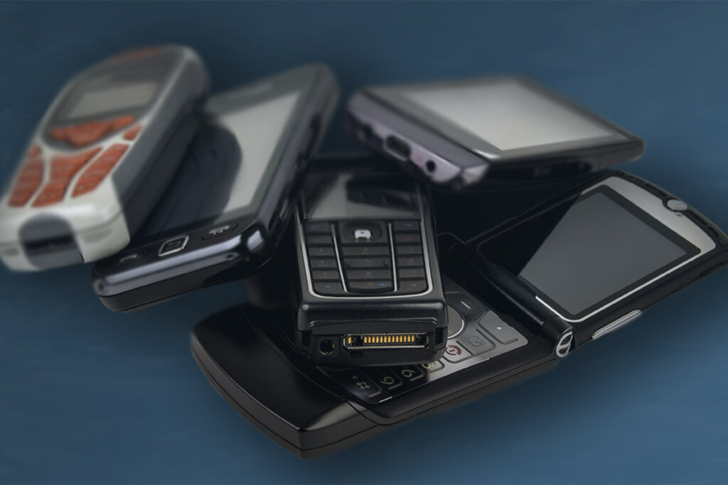 flera knappsats-telefoner på ett bord, inklusive en motorola razr v3.