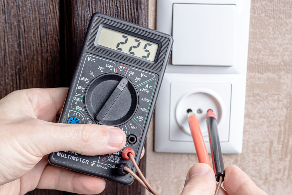 Multimeter som kontrollerar ett eluttag
