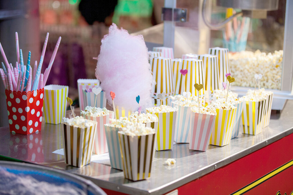 Stor popcornmaskin med popcornpåsar och sockervadd