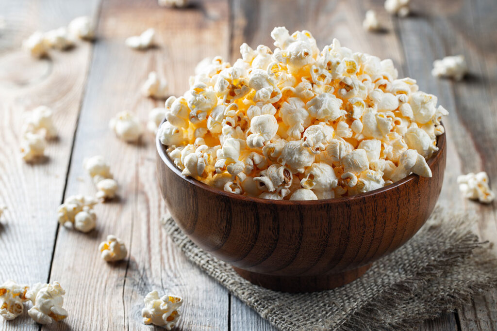 Färska popcorn i träskål på träbord