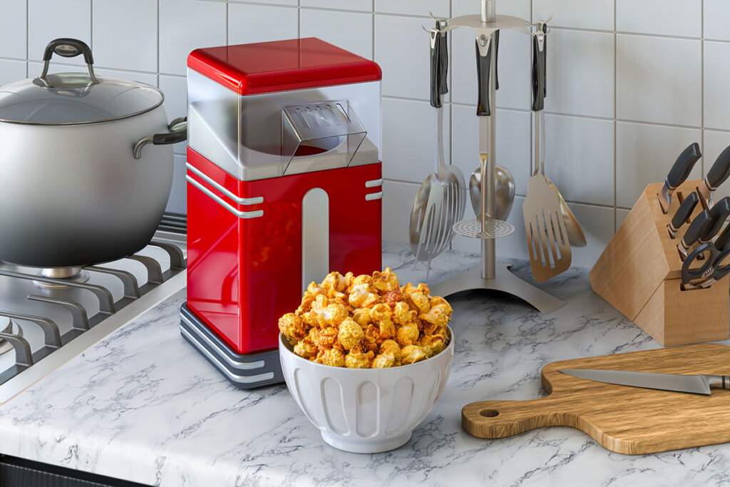 Popcornmaskin och skål full av popcorn står i köket
