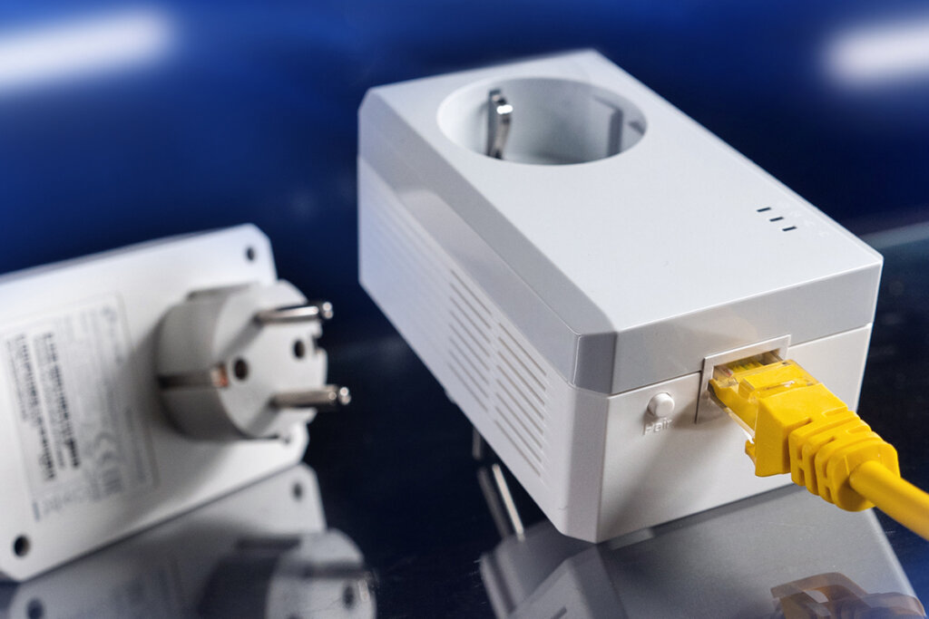 Powerline-adapter med synligt genomgångsuttag på baksidan av enheten.