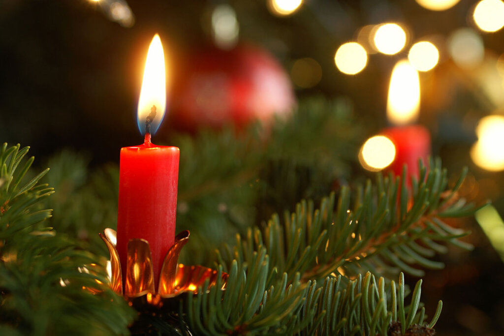 Ett brinnande julgransljus i julgranen