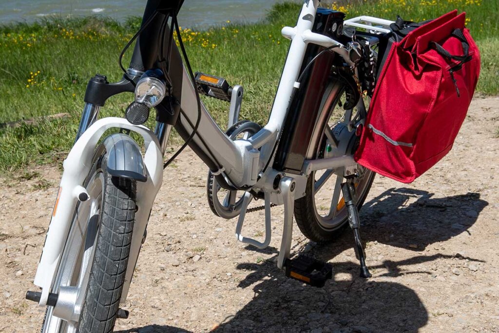 vit hopfällbar elcykel framför en flod
